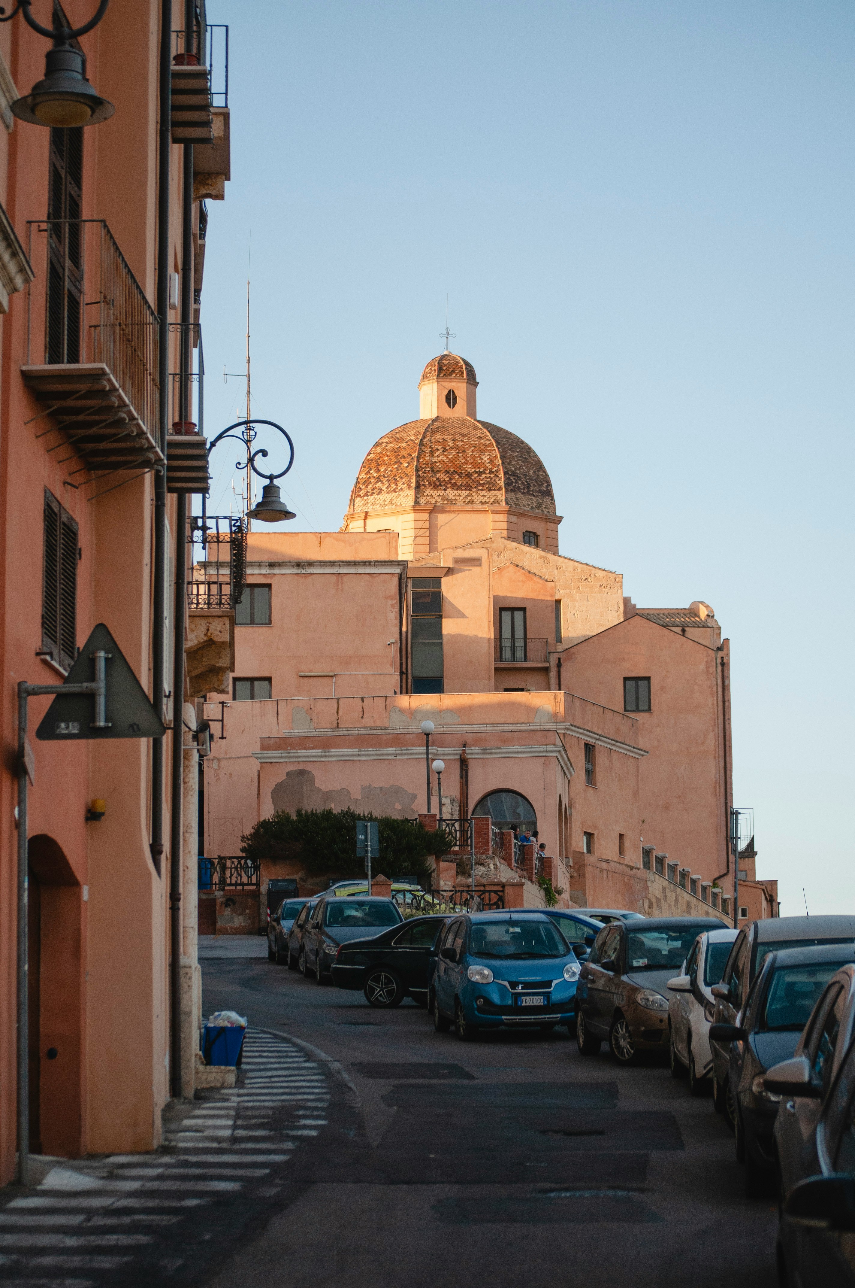 cars parked in front of brown concrete building during daytime